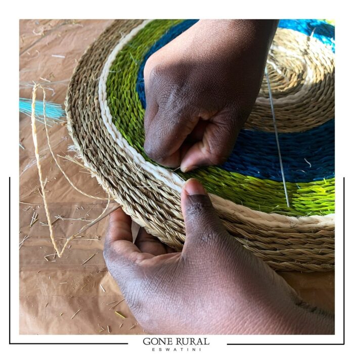 Gone Rurals vævere, har specialiseret sig i en særlig fletteteknik og bruger lange nåle - ofte lavet af genbrugte paraplyer - til at fastgøre og sy lange tråde af flettet græs sammen. Garnet er også håndlavet, rullet med sisal, et invasivt ukrudt, som vokser vildt i den sydlige region ESwatini!⁠